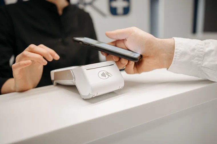 Person using smartphone for contactless mobile payment, representing the fast online Crane Finance loan application